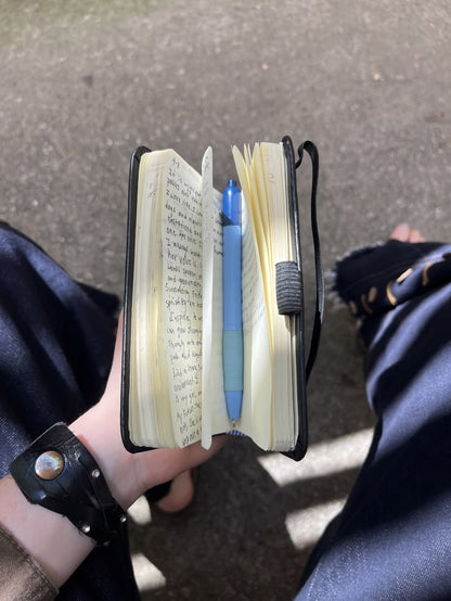 Black A6 pocket journal held in one hand